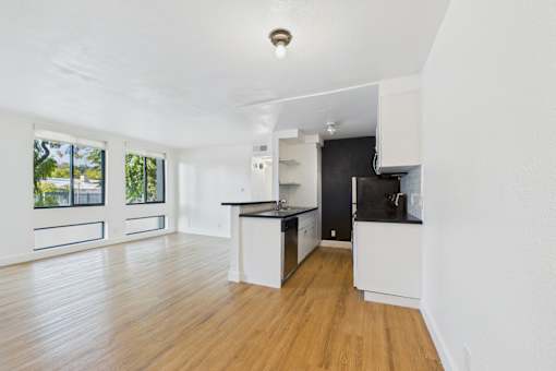 A kitchen with a black fridge and white cabinets.