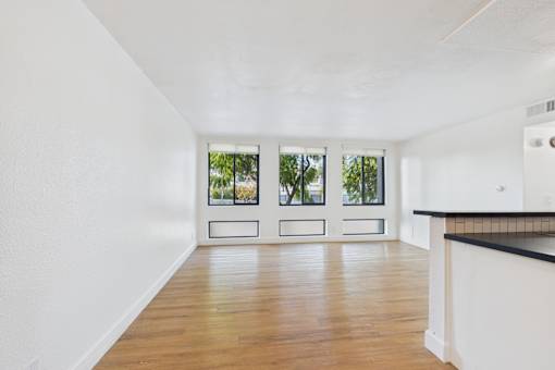 A room with wooden floors and white walls with a window.