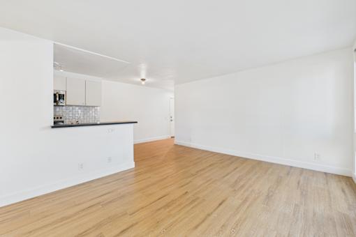 A room with wooden flooring and white walls.