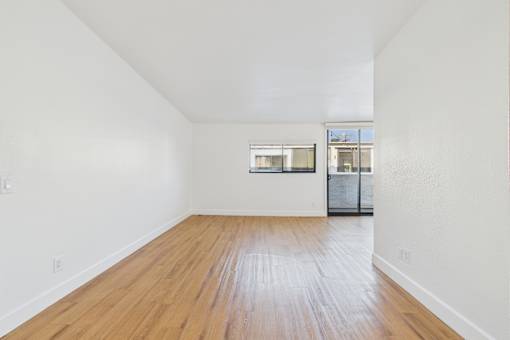 Empty room with wooden floor and white walls.
