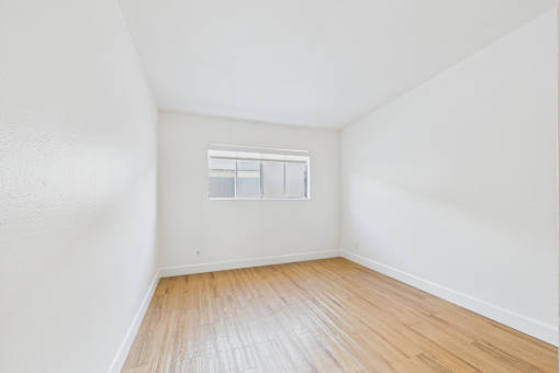 Empty room with wooden floor and a window.