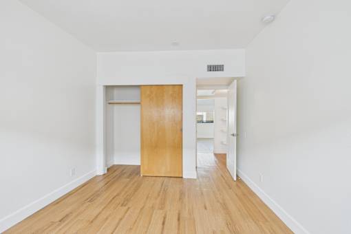 A room with a wooden floor and a wooden door.