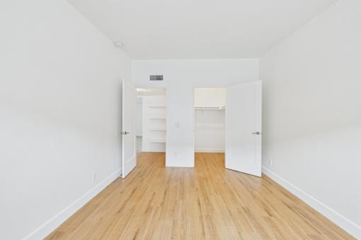 A long hallway with white walls and wood floors.