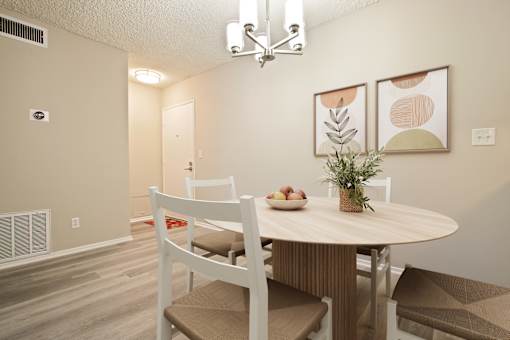 A dining room with a round table and chairs.