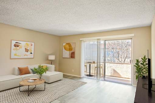 A living room with a white couch, a coffee table, and a painting on the wall.