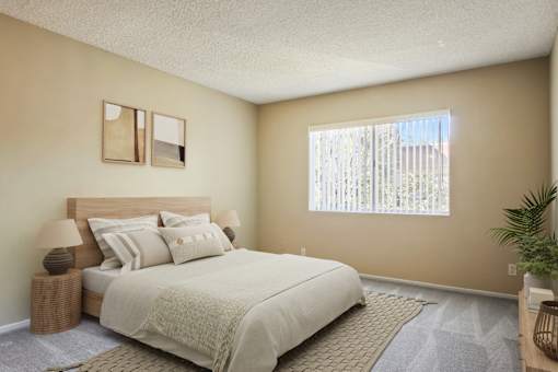 A bedroom with a large bed and a window with blinds.