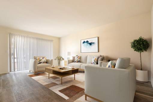 A living room with a grey couch, a coffee table, and a painting on the wall.