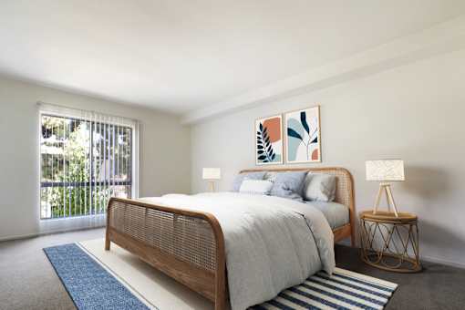 A bedroom with a bed, a nightstand, and a painting on the wall.