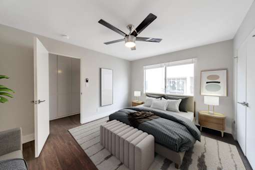 A modern bedroom with a large bed and a ceiling fan.