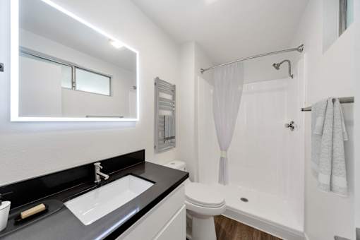A modern bathroom with a white toilet and a white shower curtain.