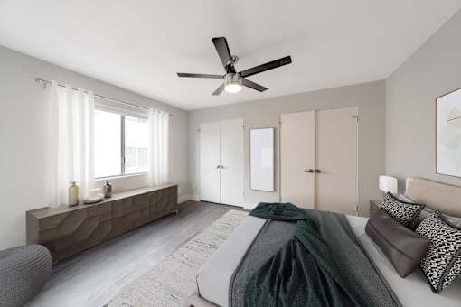 A bedroom with a bed, a chair, and a ceiling fan.