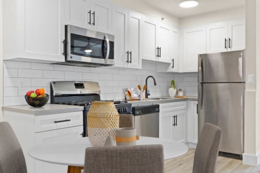 a kitchen with white cabinets and stainless steel appliances