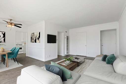 A living room with a white couch and a ceiling fan.