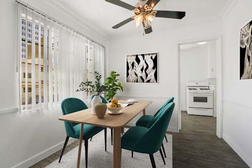 A dining room with a table, chairs, and a ceiling fan.