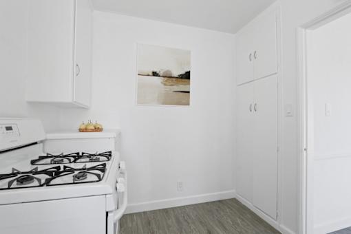 A white kitchen with a stove and cabinets.