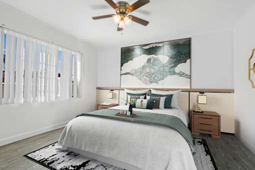 A bedroom with a large bed and a ceiling fan.