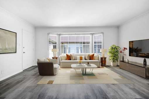 A living room with a brown and white sofa set, a coffee table, and a large painting on the wall.