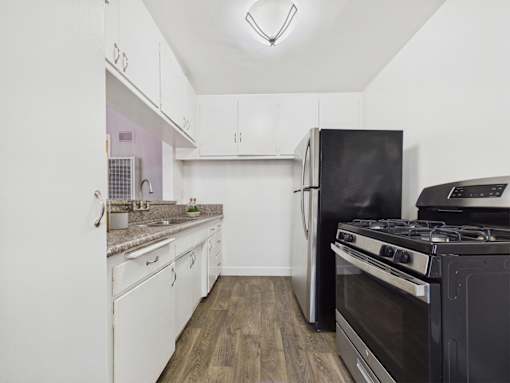A kitchen with a black stove and white cabinets.