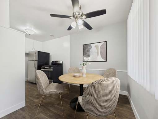 A dining room with a table and chairs.