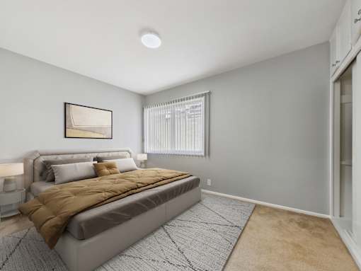 A bedroom with a large bed and a framed picture on the wall.