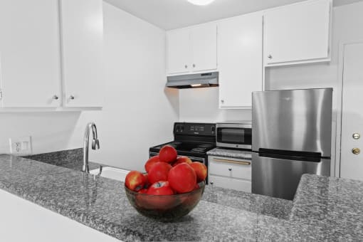 a kitchen with stainless steel appliances and a bowl of apples