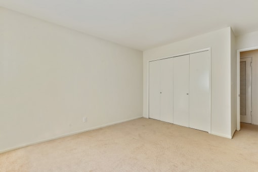 Bedroom with sliding closet doors, carpet flooring