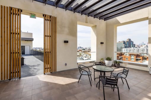 a balcony with a table and chairs and a view of the city