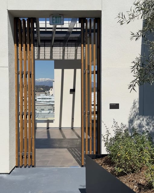 the entrance to the building has a glass door with a view of the city and