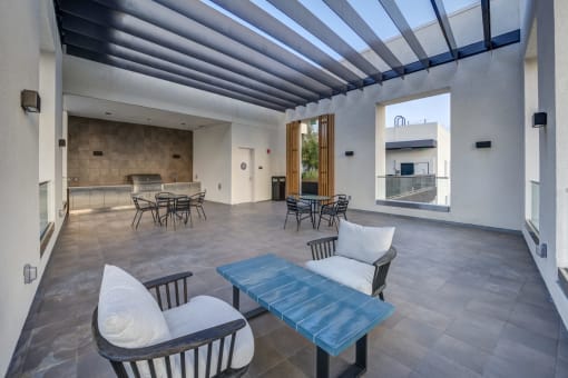 a living room with chairs and tables and a large window