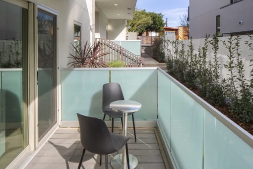 a small balcony with two chairs and a table
