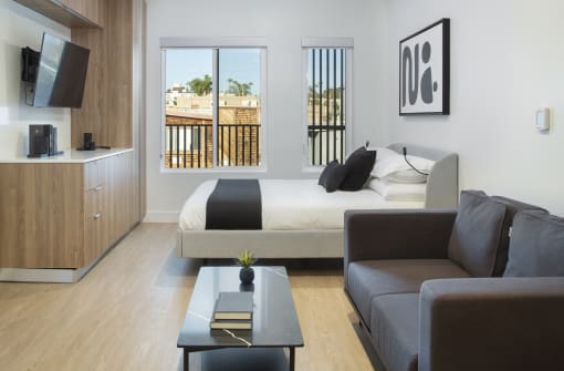a bedroom with a bed and a couch and a coffee table