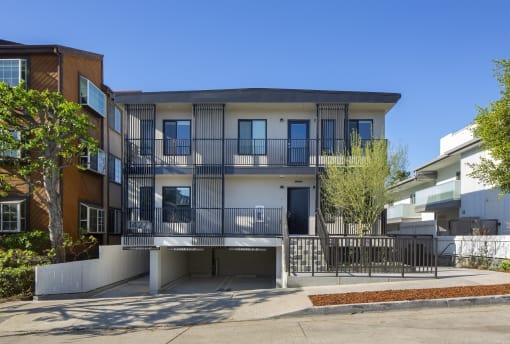 an apartment building with balconies and a sidewalk