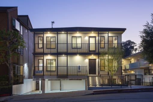 the facade of a condo building with balconies at night