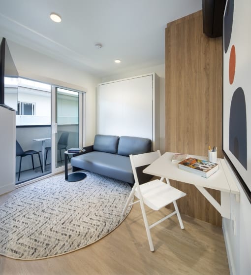 a small living room with a desk and a couch