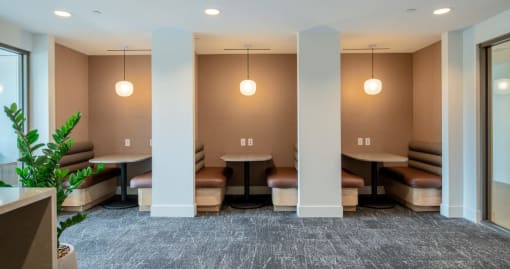 a lounge area with tables and chairs in a room