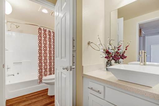 A white bathroom with a white sink and a white toilet.