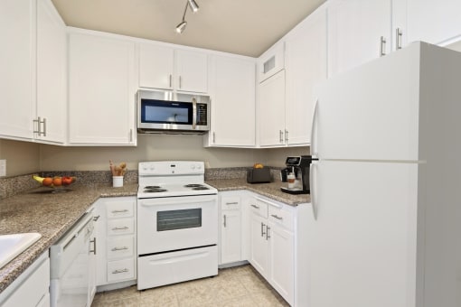a kitchen with white appliances and white cabinets