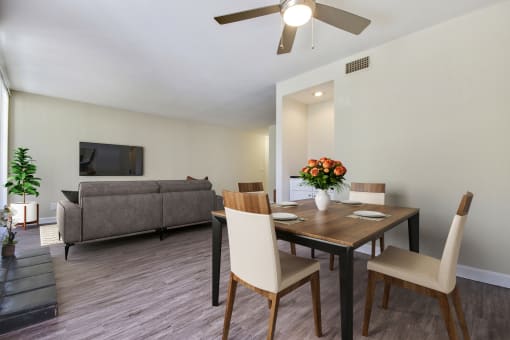 a living room and dining room with a table and chairs