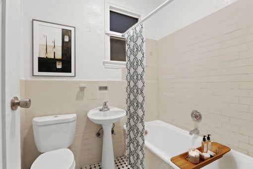 a bathroom with a toilet sink and tub and a shower curtain