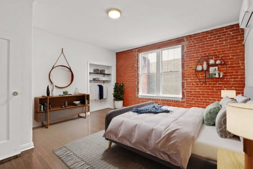 a bedroom with a bed and a brick wall