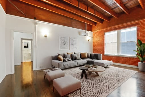 a living room with exposed brick walls and a gray couch