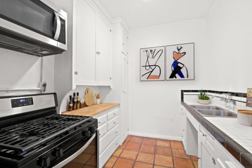 a kitchen with a stove and a sink and a microwave