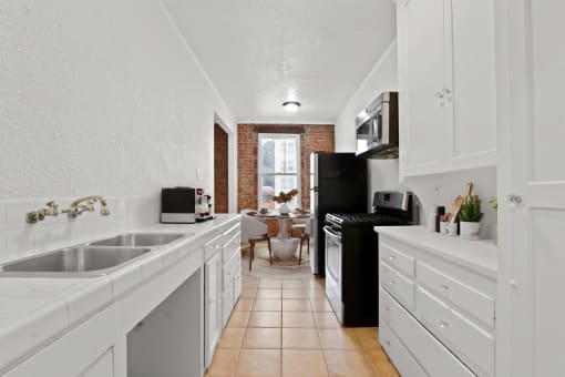a kitchen with white cabinets and a black stove and refrigerator