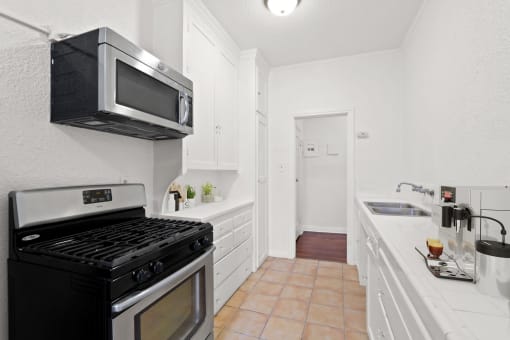 a kitchen with a stove and a microwave and a sink