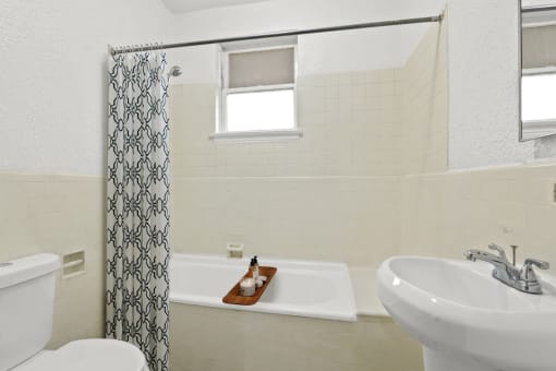 a bathroom with a sink toilet and tub and a shower curtain
