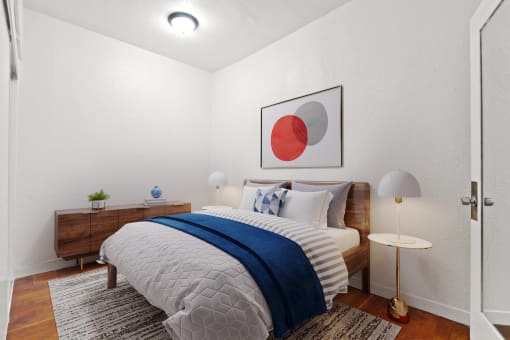 a bedroom with white walls and a bed with a blue blanket