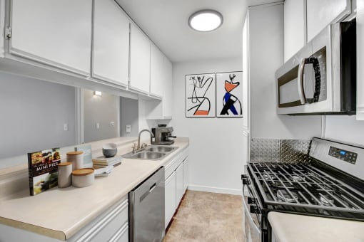 a kitchen with white cabinets and a stove and a sink