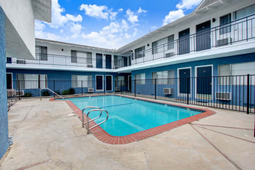 a swimming pool with a blue and white building in the background