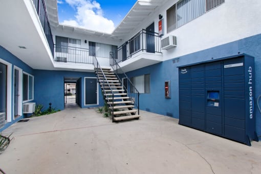 a stairway leading up to a white and blue building with a blue garage door