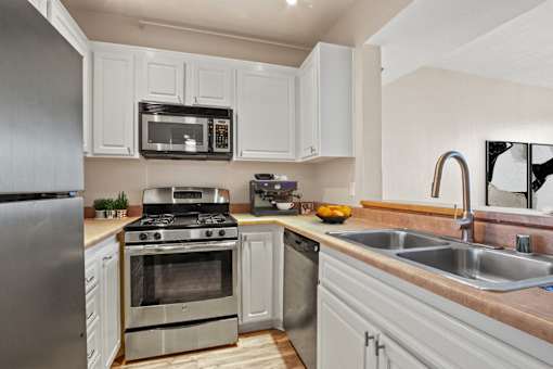 A modern kitchen with white cabinets and stainless steel appliances.